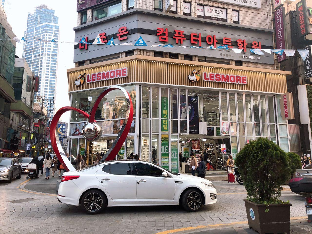 釜山西面购物商圈入口处的LESMORE商店，旁边有一个心形雕塑。